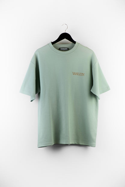 Innocent Green Tee mit VANLEEN Logo in Braun, Oversized Fit, minimalistisches Design, gesticktes X-Detail am Rücken, sanfter Grünton, moderner Streetwear Look